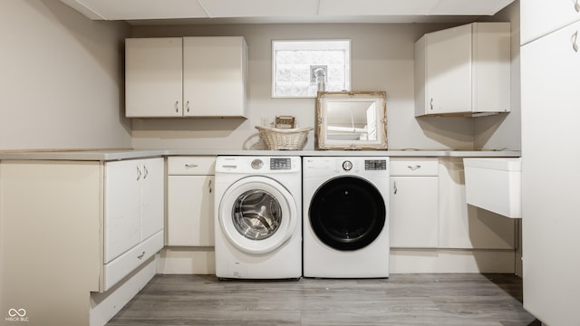 5809 N Washington Blvd, Indianapolis, IN 46220 - laundry area with cabinet space, washer and clothes dryer, and light wood-style flooring