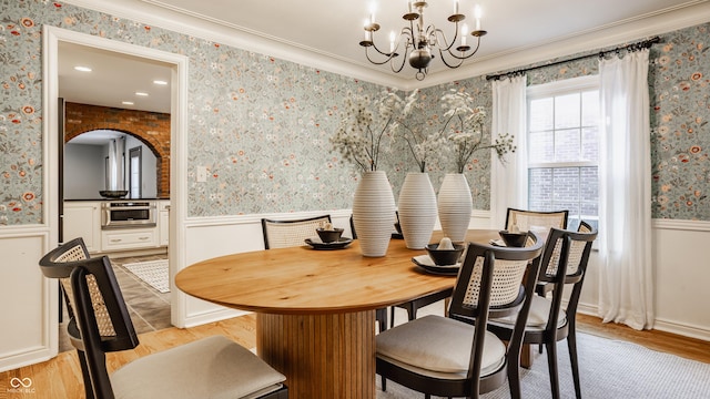 5809 N Washington Blvd, Indianapolis, IN 46220 - dining space with a chandelier, a wainscoted wall, wallpapered walls, light wood-type flooring, and ornamental molding