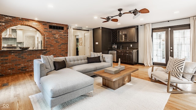 5809 N Washington Blvd, Indianapolis, IN 46220 - living room featuring light wood-style floors, brick wall, arched walkways, wet bar, and a ceiling fan