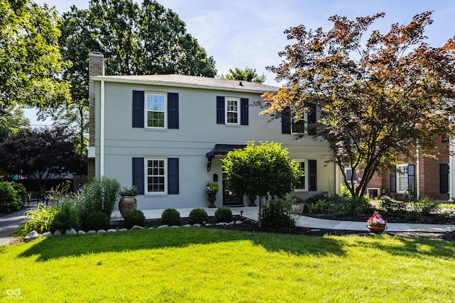 5809 N Washington Blvd, Indianapolis, IN 46220 - colonial-style house with a chimney, a front yard, and brick siding