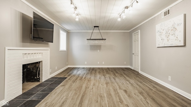 5809 N Washington Blvd, Indianapolis, IN 46220 - unfurnished living room with rail lighting, wood finished floors, crown molding, and a fireplace