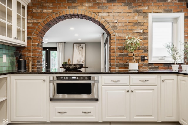 5809 N Washington Blvd, Indianapolis, IN 46220 - kitchen with arched walkways, oven, glass insert cabinets, and white cabinetry