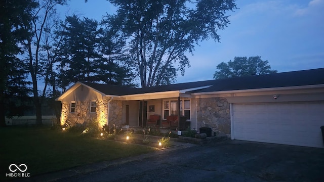 6974 S County Road 400 E, Clayton, IN 46118 - view of front facade with stone siding, a porch, driveway, and an attached garage