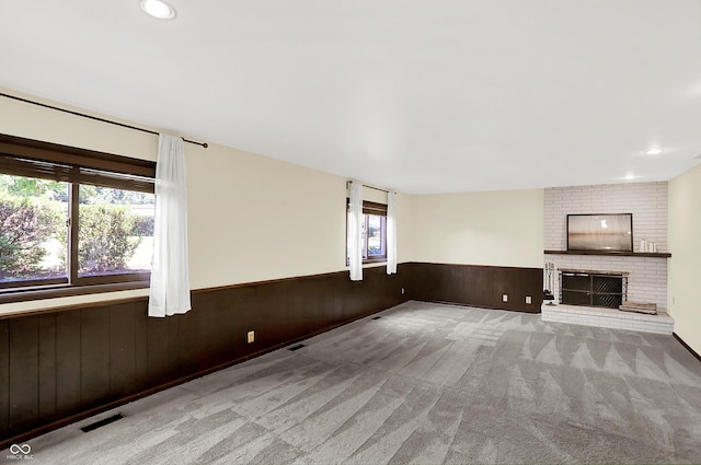 1441 Hunter Pl, Columbus, IN 47203 - unfurnished living room with wainscoting, carpet flooring, wood walls, a fireplace, and recessed lighting