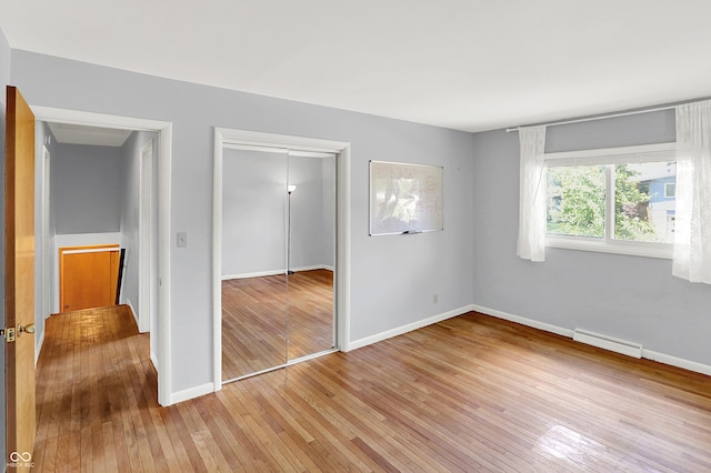 1441 Hunter Pl, Columbus, IN 47203 - unfurnished bedroom featuring light wood-style floors, a closet, and baseboard heating