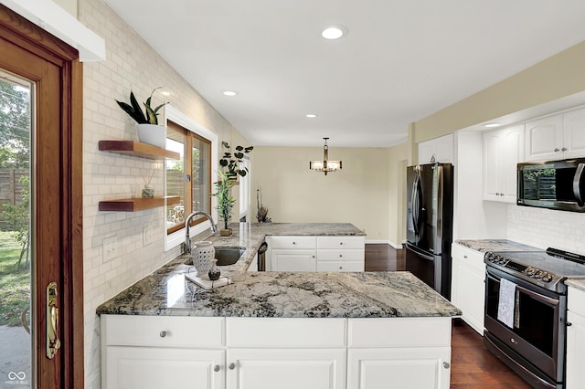 1441 Hunter Pl, Columbus, IN 47203 - kitchen with appliances with stainless steel finishes, a peninsula, open shelves, decorative backsplash, and plenty of natural light