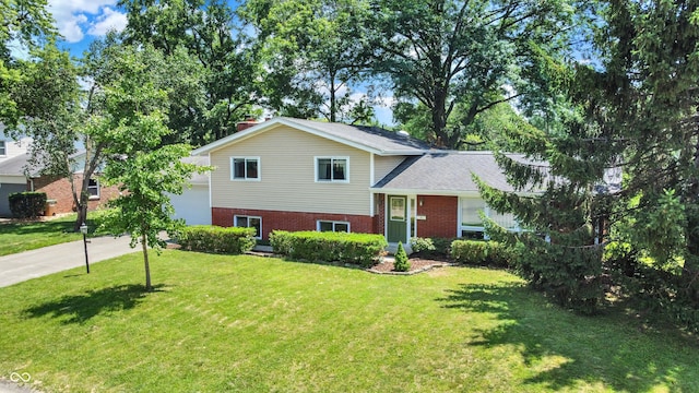 1441 Hunter Pl, Columbus, IN 47203 - tri-level home with driveway, brick siding, a front yard, a chimney, and a garage