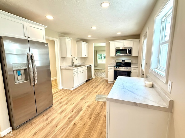 1809 Beam Rd, Columbus, IN 47201 - kitchen featuring appliances with stainless steel finishes, light wood-style floors, white cabinets, recessed lighting, and light countertops