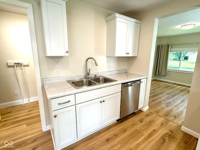 1809 Beam Rd, Columbus, IN 47201 - kitchen with light wood-style flooring, light countertops, stainless steel dishwasher, and white cabinets