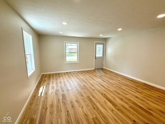 1809 Beam Rd, Columbus, IN 47201 - spare room featuring light wood-style flooring, a textured ceiling, and recessed lighting