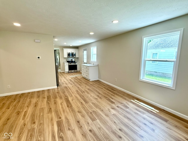 1809 Beam Rd, Columbus, IN 47201 - unfurnished living room featuring light wood-style floors, recessed lighting, and a textured ceiling