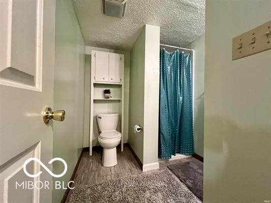 9406 S Lake Ridge Dr, Bloomington, IN 47401 - full bathroom featuring a shower with curtain, a textured ceiling, and wood finished floors
