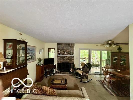 9406 S Lake Ridge Dr, Bloomington, IN 47401 - living area featuring a textured ceiling, ceiling fan, and a fireplace