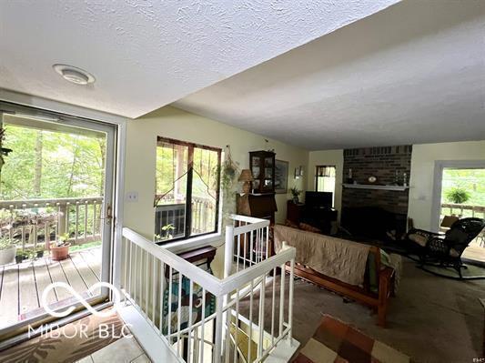 9406 S Lake Ridge Dr, Bloomington, IN 47401 - living room featuring a textured ceiling and a fireplace