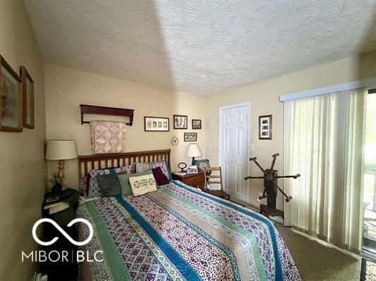 9406 S Lake Ridge Dr, Bloomington, IN 47401 - bedroom with carpet floors and a textured ceiling