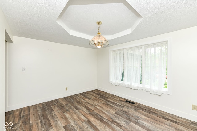 6413 Amber Pass, Plainfield, IN 46168 - empty room featuring a chandelier, a tray ceiling, a textured ceiling, and dark wood-type flooring