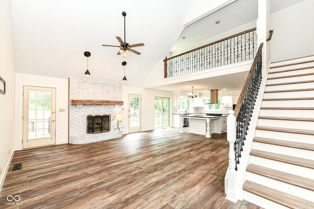 6413 Amber Pass, Plainfield, IN 46168 - unfurnished living room featuring a ceiling fan, stairs, a fireplace, wood finished floors, and plenty of natural light