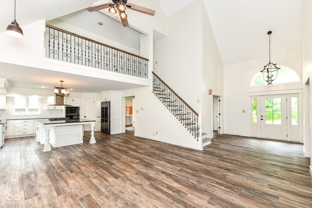 6413 Amber Pass, Plainfield, IN 46168 - unfurnished living room with high vaulted ceiling, stairs, dark wood finished floors, healthy amount of natural light, and a chandelier
