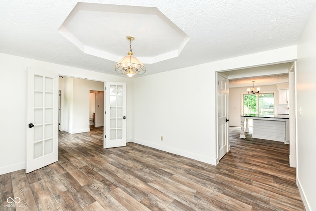 6413 Amber Pass, Plainfield, IN 46168 - empty room with a chandelier, french doors, wood finished floors, a textured ceiling, and a tray ceiling