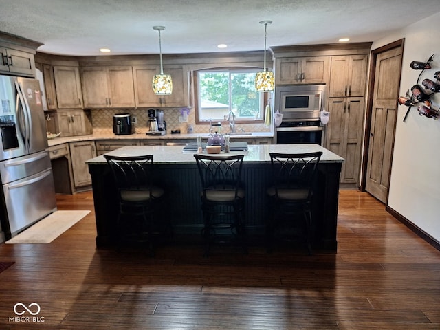 681 Hancock School Rd, Spencer, IN 47460 - kitchen featuring appliances with stainless steel finishes, tasteful backsplash, hanging light fixtures, an island with sink, and dark wood-style flooring