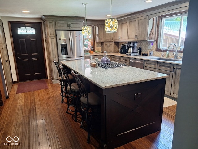 681 Hancock School Rd, Spencer, IN 47460 - kitchen featuring appliances with stainless steel finishes, a center island, dark wood-style flooring, tasteful backsplash, and a kitchen breakfast bar