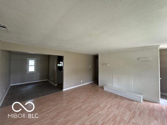 4463 N Bolton Ave, Indianapolis, IN 46226 - unfurnished living room with a textured ceiling and wood finished floors