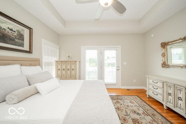 7929 W Bristol Way, New Palestine, IN 46163 - bedroom with access to outside, light wood-type flooring, a raised ceiling, and a ceiling fan