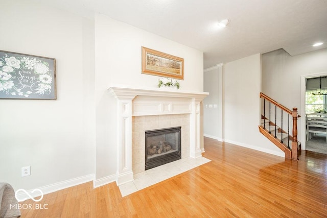 7929 W Bristol Way, New Palestine, IN 46163 - unfurnished living room with wood finished floors, stairway, a tiled fireplace, and recessed lighting