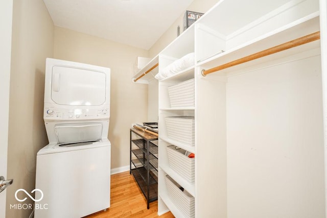 7929 W Bristol Way, New Palestine, IN 46163 - walk in closet featuring stacked washing machine and dryer and light wood-style flooring