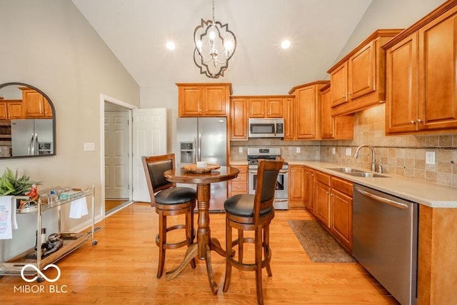 7929 W Bristol Way, New Palestine, IN 46163 - kitchen with stainless steel appliances, backsplash, light wood finished floors, brown cabinetry, and light countertops