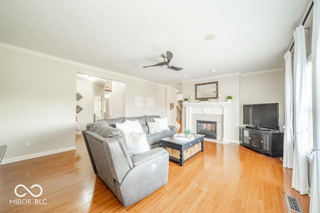 7929 W Bristol Way, New Palestine, IN 46163 - living area with light wood-style floors, crown molding, a ceiling fan, and a fireplace with flush hearth