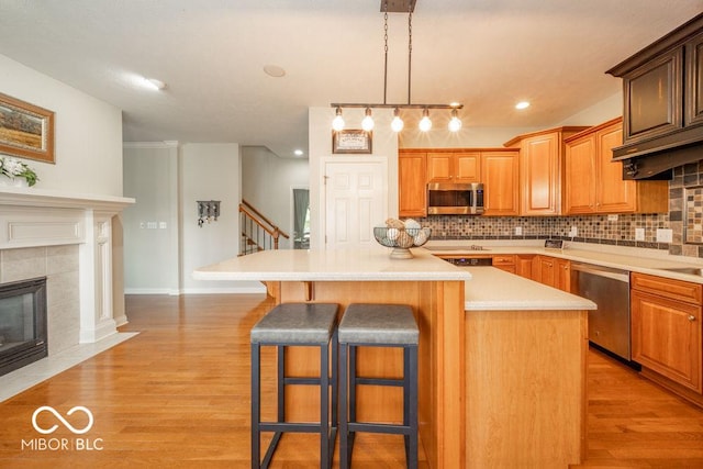 7929 W Bristol Way, New Palestine, IN 46163 - kitchen featuring stainless steel appliances, a breakfast bar, a kitchen island, tasteful backsplash, and light countertops