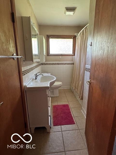 bathroom featuring tile patterned floors, vanity, and tile walls