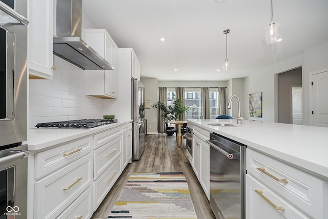 9732 Junction, Fishers, IN 46037 - kitchen with stainless steel appliances, wood finished floors, wall chimney exhaust hood, decorative backsplash, and light countertops