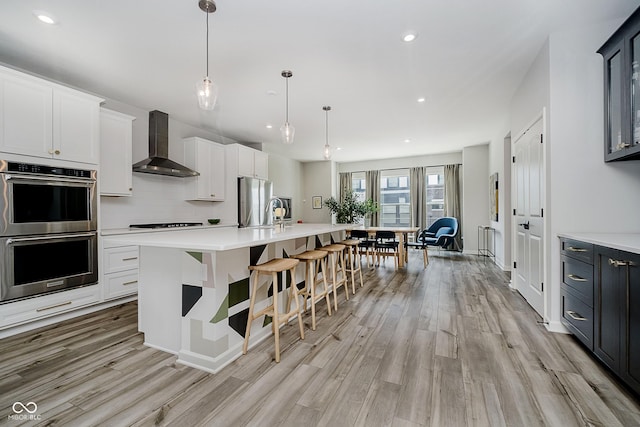9732 Junction, Fishers, IN 46037 - kitchen with appliances with stainless steel finishes, light wood-type flooring, wall chimney range hood, light countertops, and recessed lighting