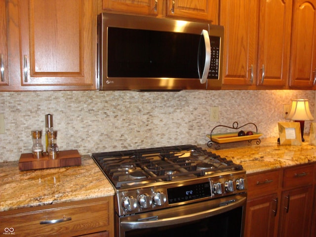 7839 Jessica Ct, Avon, IN 46123 - kitchen with appliances with stainless steel finishes, decorative backsplash, light stone countertops, and brown cabinets