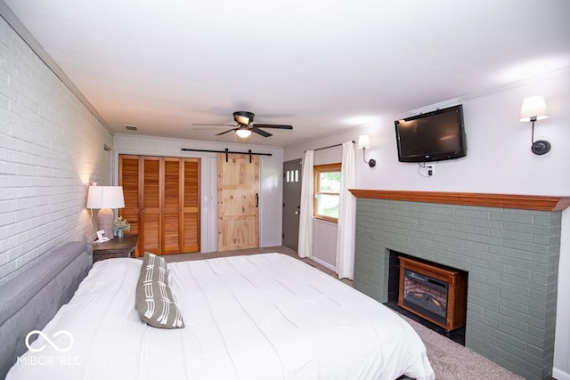 8310 N County Road 700 W, Scipio, IN 47273 - bedroom with a barn door, a fireplace, brick wall, a ceiling fan, and crown molding
