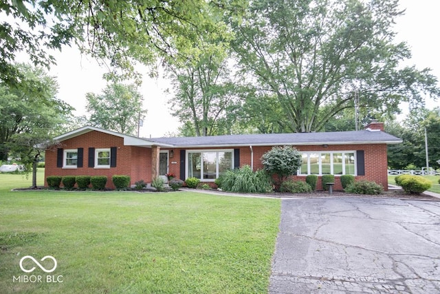 8310 N County Road 700 W, Scipio, IN 47273 - ranch-style house with brick siding, a front yard, and a chimney
