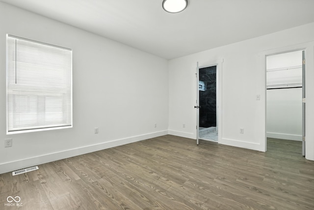 2000 N Dexter St, Indianapolis, IN 46202 - unfurnished bedroom featuring wood finished floors, a spacious closet, and connected bathroom