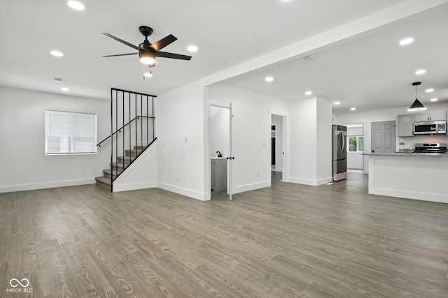 2000 N Dexter St, Indianapolis, IN 46202 - unfurnished living room featuring wood finished floors, ceiling fan, stairway, and recessed lighting