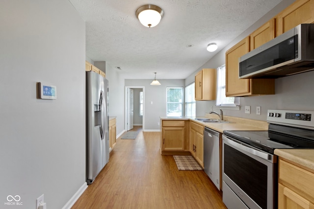 11426 High Grass Dr, Indianapolis, IN 46235 - kitchen featuring stainless steel appliances, light brown cabinets, light wood finished floors, a textured ceiling, and light countertops