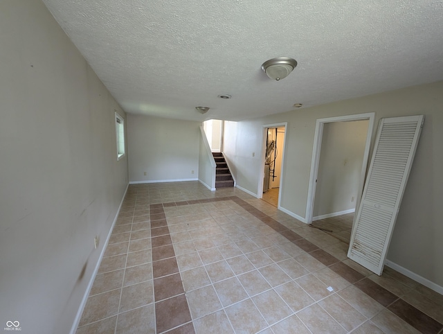 8454 Saxon Ct, Columbus, IN 47201 - empty room with tile patterned flooring, stairway, and a textured ceiling