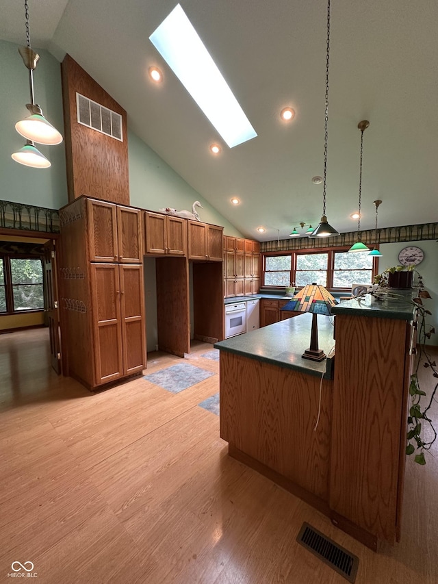 2765 S 1200 E, Zionsville, IN 46077 - kitchen with a skylight, vaulted ceiling, white oven, brown cabinets, and light wood-style flooring