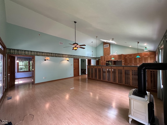 2765 S 1200 E, Zionsville, IN 46077 - unfurnished living room featuring high vaulted ceiling, a ceiling fan, a wood stove, and light wood-style flooring