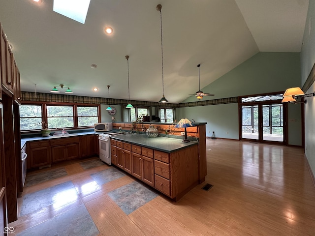 2765 S 1200 E, Zionsville, IN 46077 - kitchen featuring white appliances, high vaulted ceiling, dark countertops, brown cabinets, and light wood-style flooring