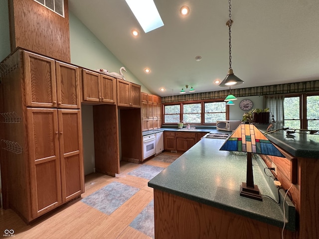 2765 S 1200 E, Zionsville, IN 46077 - kitchen with white appliances, a skylight, brown cabinetry, dark countertops, and recessed lighting