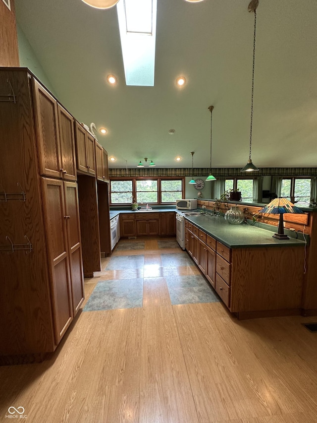 2765 S 1200 E, Zionsville, IN 46077 - kitchen with light wood-style floors, a skylight, dark countertops, decorative light fixtures, and recessed lighting