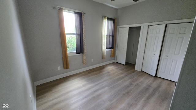 1805 S Denny St, Indianapolis, IN 46203 - unfurnished bedroom with multiple windows, multiple closets, and wood finished floors