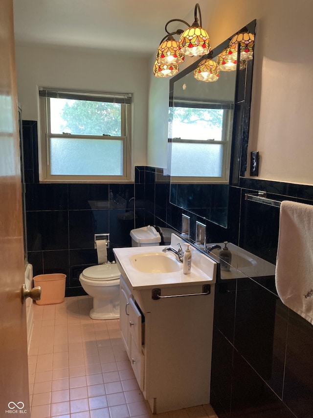 1016 N Mitchner Ave, Indianapolis, IN 46219 - bathroom featuring tile walls, tile patterned flooring, plenty of natural light, vanity, and wainscoting