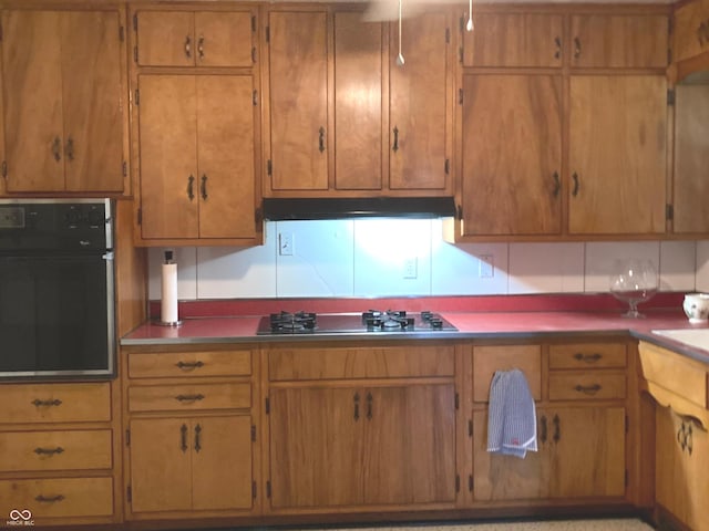 1016 N Mitchner Ave, Indianapolis, IN 46219 - kitchen featuring wall oven, gas cooktop, under cabinet range hood, and brown cabinets
